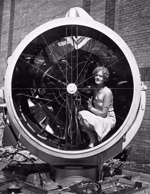 Chicago, Illinois:  August 12, 1930               A young woman sitting inside the Lindbergh lamp just before it was  hoisted to the top of the Palmolive building where it will soon be dedicated as the largest and most powerful beacon in the world. It is five feet in diameter and will have 2 billion candle power and throw a light for 500 miles.