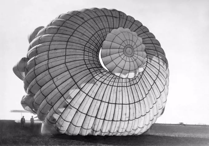 Los Angeles, California:  c. 1926 The world's largest parachute at 85 feet in diameter with which Heard (Herd) McClellan will stall his airplane and then deploy the chute which is attached to the plane and float back to earth while still in the cockpit.