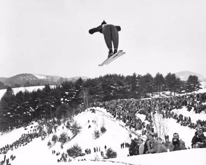 Hanover, New Hampshire:  c. 1955 A back view of a skier going off the ski jump at the annual Winter Carnival of the Dartmouth Outing Club.