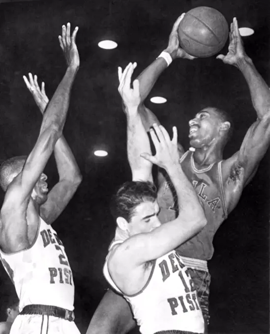 Detroit, MIchigan:  February 8, 1961 Detroit Piston players Walter Dukes, (left) and George Lee can't get high enough to block the Philadelphia Warriors'  Wilt Chamberlain's shot.