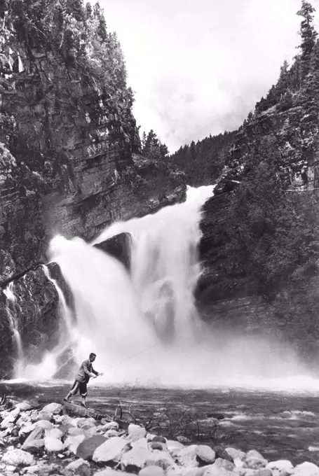 Waterton Lakes National Park, Alberta, Canada:  September 4, 1929 A man trout fishing below Cameron Falls.