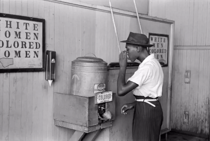 Oklahoma City, Oklahoma:  July, 1939 A Negro drinking at "Colored" water cooler in a streetcar terminal,
