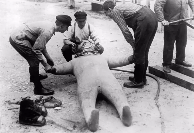 Berlin, Germany:  c. 1932 Photographer and photojournalist Willie Ruge has endeavored to take the first underwater photographs outside of a diving bell.  Here the diving suit is inflated afterwards to prevent cracking in the surface of the suit.