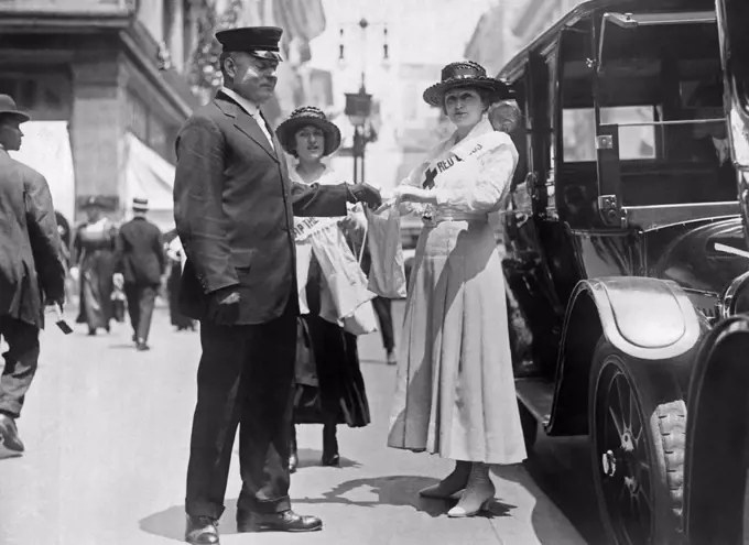 New York, New York:   June 25, 1917 A chauffeur on Fifth Avenue contributes his portion to the Red Cross' great $100,000,000 war fund drive.