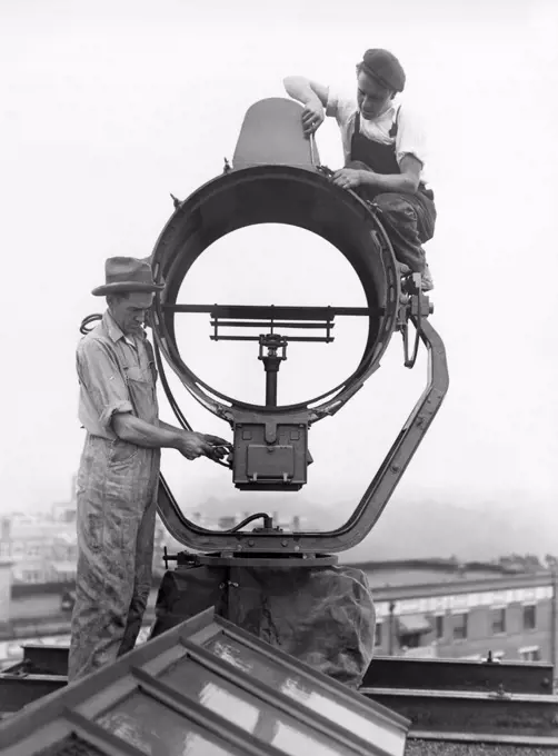 Washington, D.C.:  July 22, 1929 Workmen installing the new half million candle power beacon atop the Wardman Park Hotel to provide guidance for avaiators arriving at night in the nation's capital.