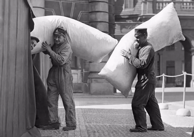 Stockholm, Sewden:  1938 Royal Castle guards moving their bedding into temporary tent quarters while the Stockholm regiments are under scarlet fever quarantine.