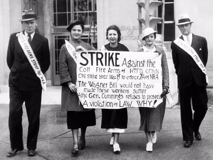 Washington, D.C.:  May 23, 1935 Men and women picketing in front of the Federal Bureau of Investigation office. They are protesting the lack of Federal action in the strike at the Colt Firearms plant in Hartford, Connecticut where the machine guns used by the Federal officers are manufactured.