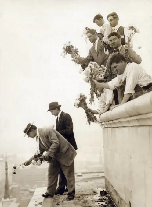 Cincinnati, Ohio:   May 20, 1913 Workmen standing on the ledge of the Union Central Building throw flowers down on the passing streetcars in honor of the end of the streetcar traction strike. Only a few days before blocks of concrete and iron bars were thrown down by the strike sympathizers, demolishing one streetcar and narrowly avoiding injuring many people.