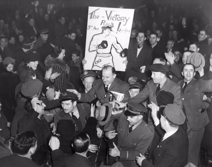 New York, New York:   1937 Members of the Transit Workers Union carry their international president, Michael J. Quill, up to the speakers' platform during a bus strike union meeting.