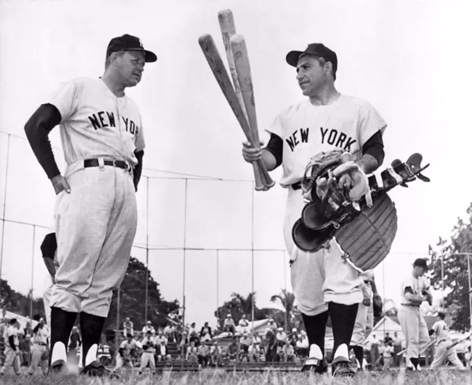 St. Petersburg, Florida:  February 20, 1961 Yankee catcher, outfielder, occasional infielder plus pinch hitter Yogi Berra strolls past manager Ralph Houk carrying his tools of the trade on his first day of spring training.