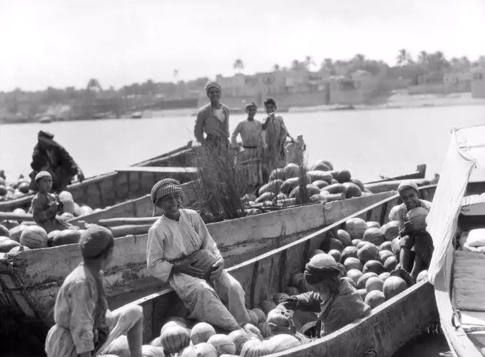 Baghdad, Iraq:  1932 Iraqi boys with barges of watermelons on the Tigris River.