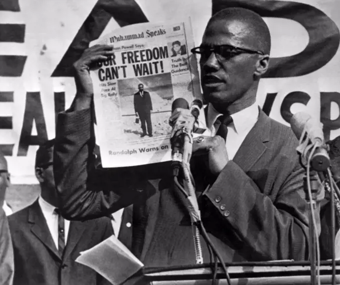 New York, New York:  July 27, 1963   "Malcolm X, Black Muslim leader, holds up paper for the crowd to see during Black Muslim rally in New York City. In their rallies the Muslims, an African Nationalist organization, preach a philosophy of "hate the white man". The Black Muslims are one of the extremest groups within the Negro community.". The above is the original caption from the Associated Press for the photograph which was to run on August 5th with an article by Junius Griffin.