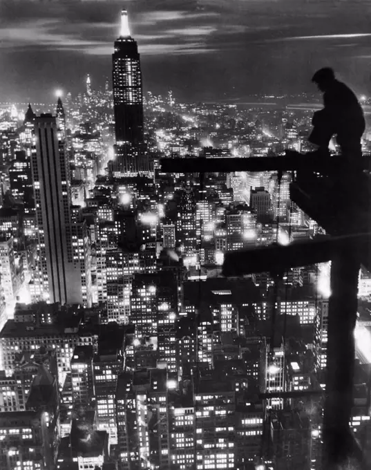 New York, New York: November 18, 1932 A workman pauses to admire the newly completed Empire State Building and the New York City skyline. The view is probably from the top of the RCA Building in Rockefeller Center which was completed in 1933.