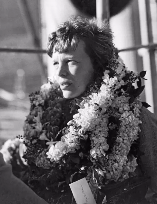 Honolulu, Hawaii: December 27, 1934 A closeup of the country's most outstanding woman flyer, Amelia Earhart Putnam as she arrives on her first visit to the Territory of Hawaii and is greeted by her admirers with floral leis.