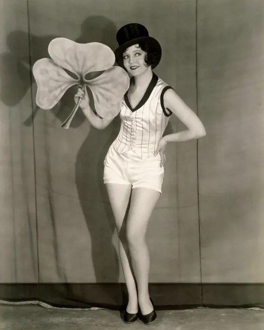 Young woman standing on a stage holding a clover