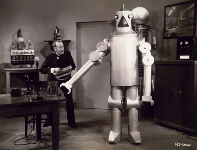 Senior man standing near a robot