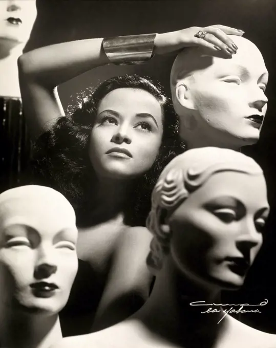 Close-up of a young woman posing with mannequins