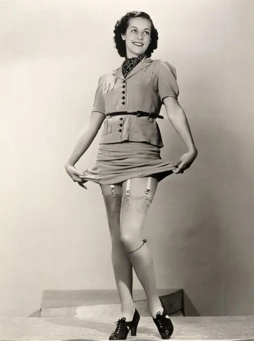 Young woman holding up her dress showing her stockings