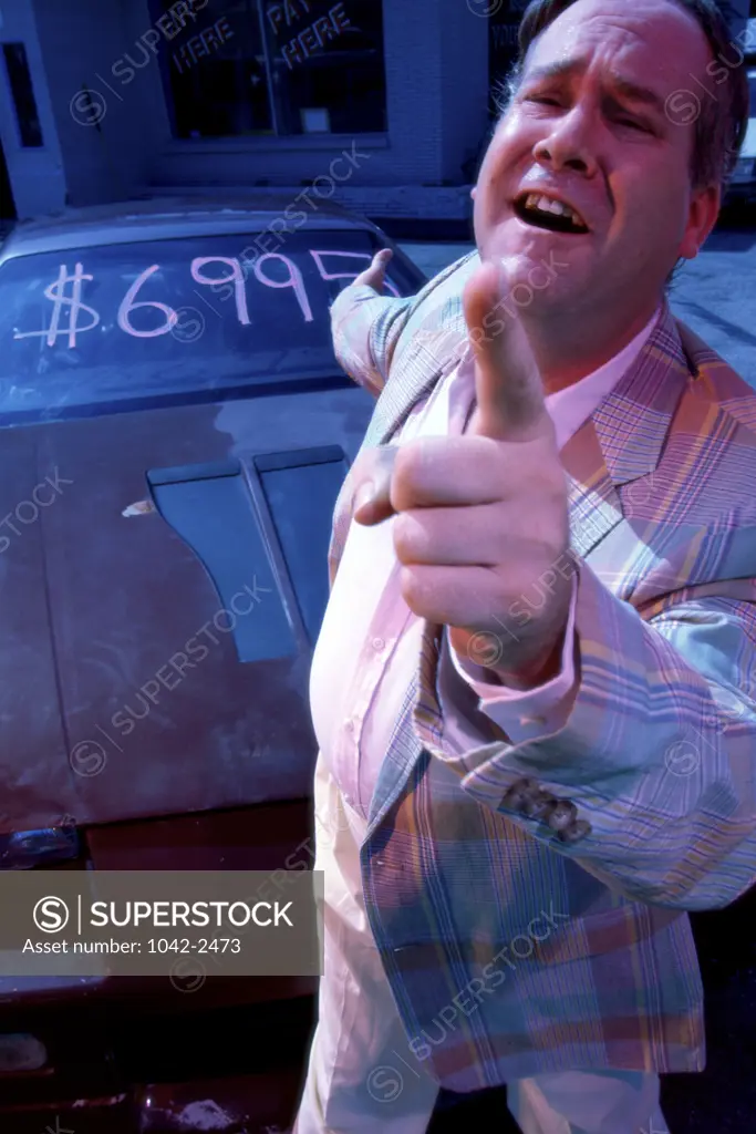 Mature man pointing to a car