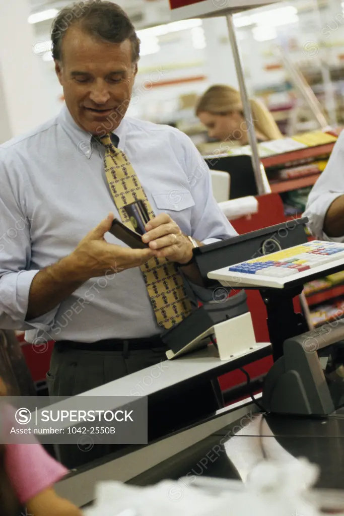 Mature man holding a credit card at a checkout counter