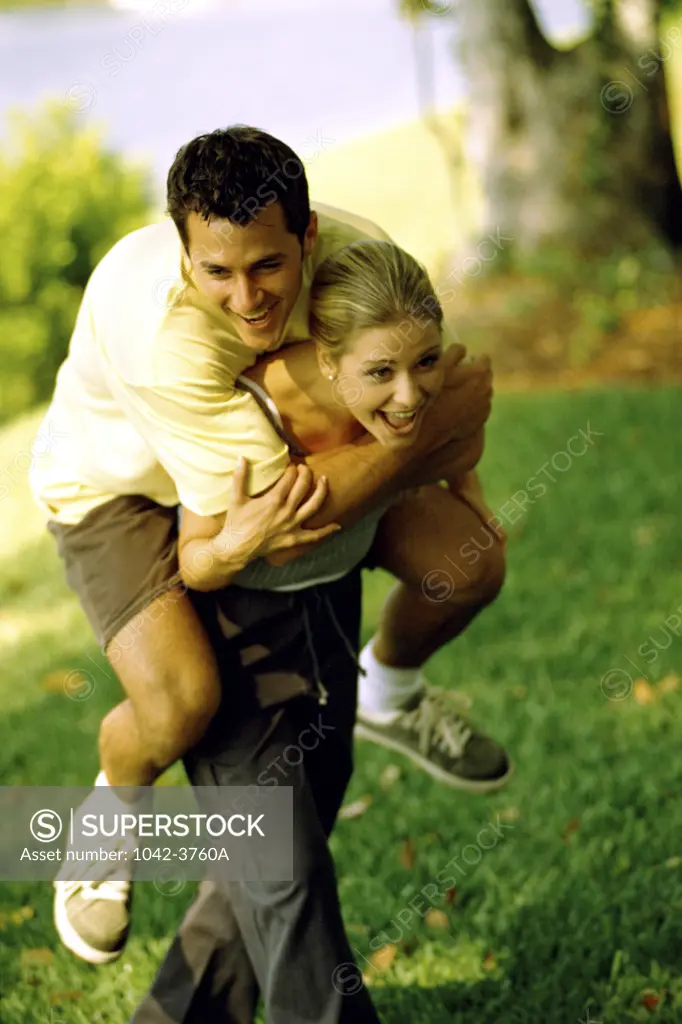 Young man riding piggyback on a young woman