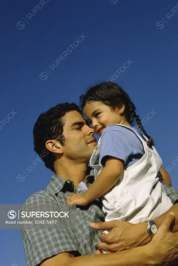 Low angle view of a father carrying his daughter