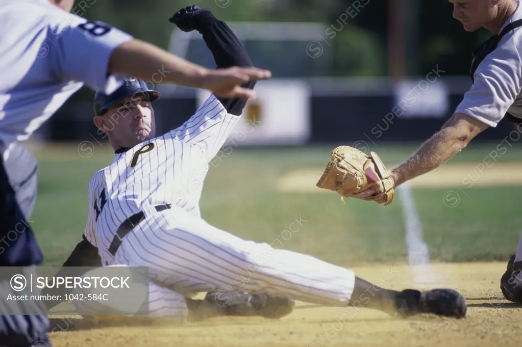 Baseball player sliding into home base