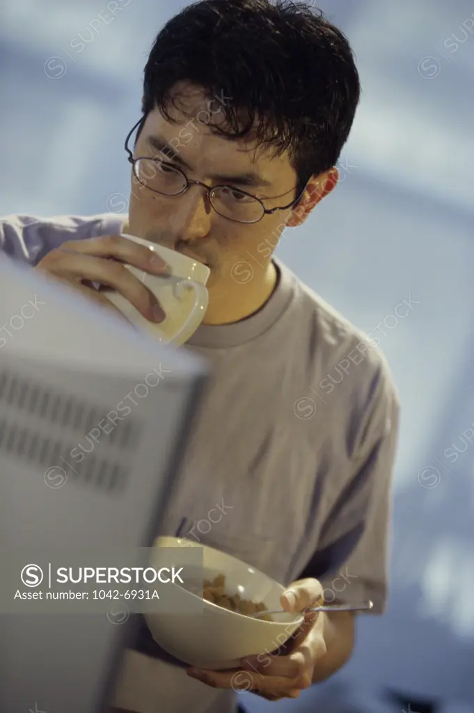 Close-up of a young man sitting in front of a computer monitor