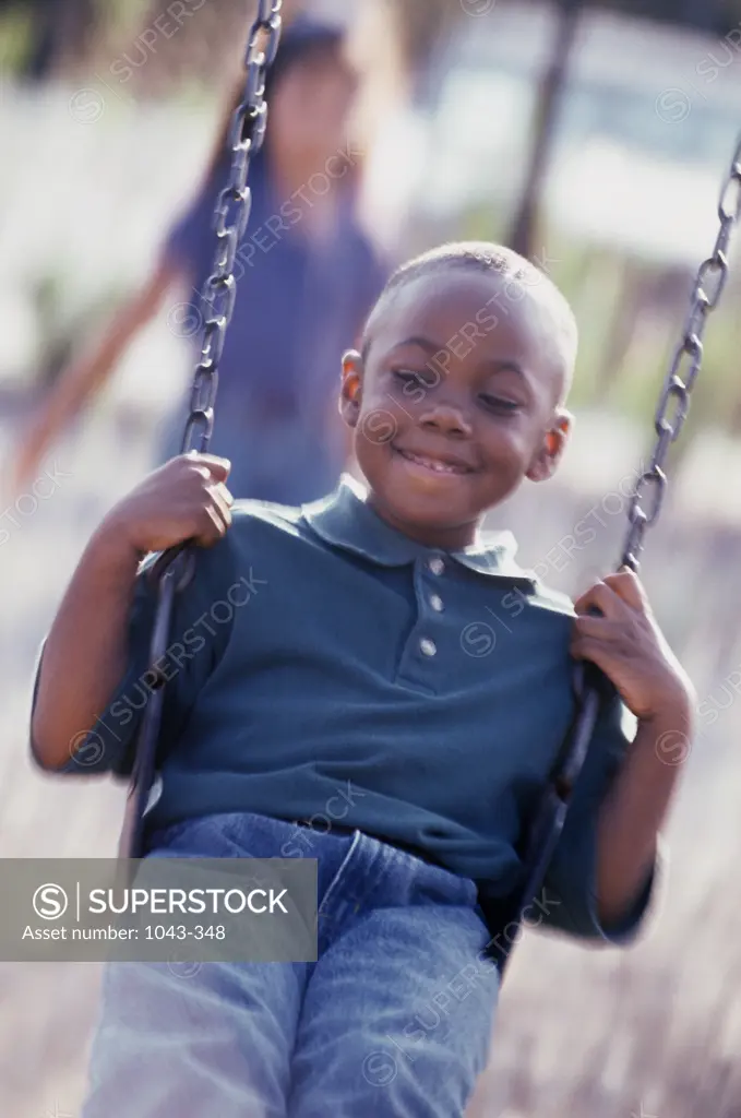 Close-up of a boy swinging on a swing