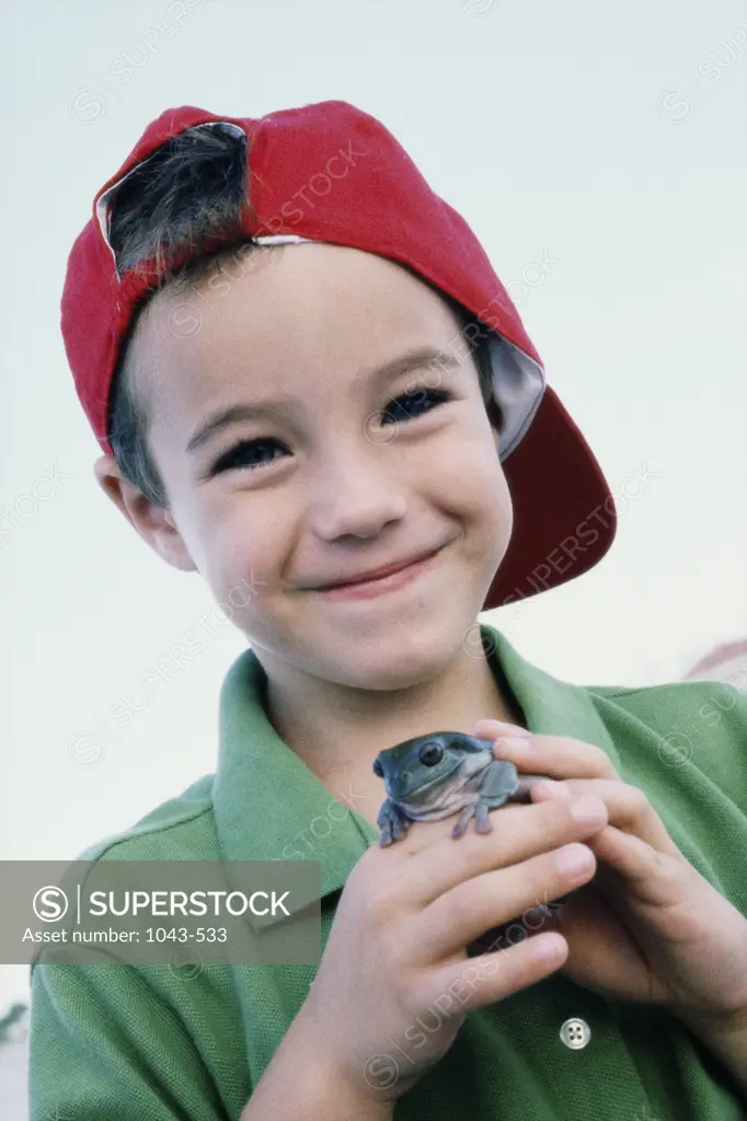 Portrait of a boy holding a frog