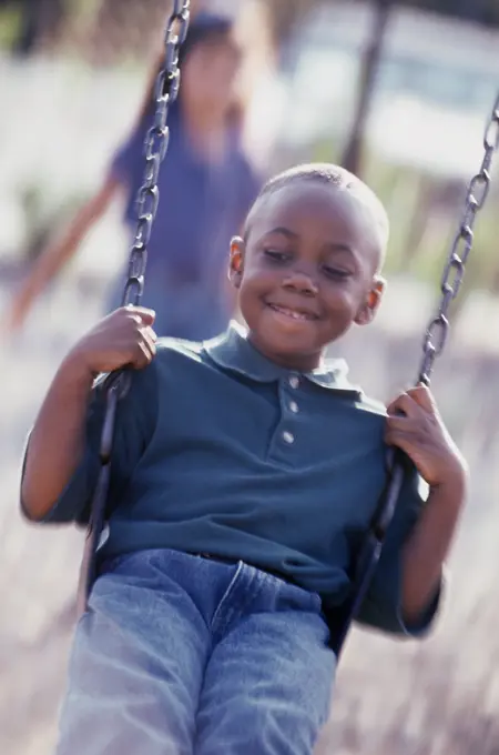 Close-up of a boy swinging on a swing