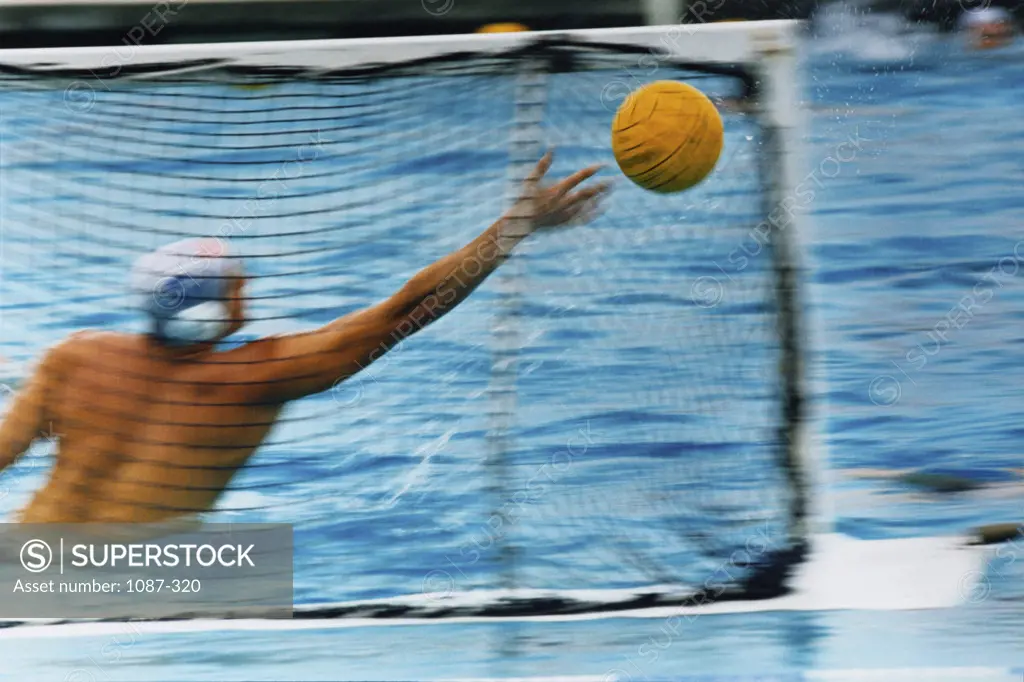 Rear view of a man playing water polo in a swimming pool