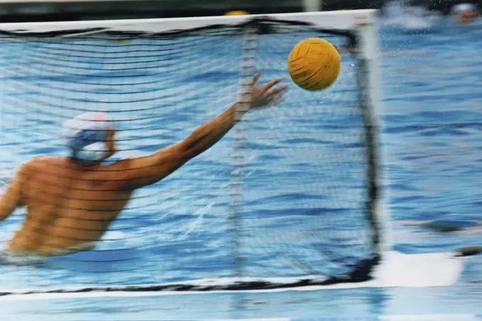 Rear view of a man playing water polo in a swimming pool