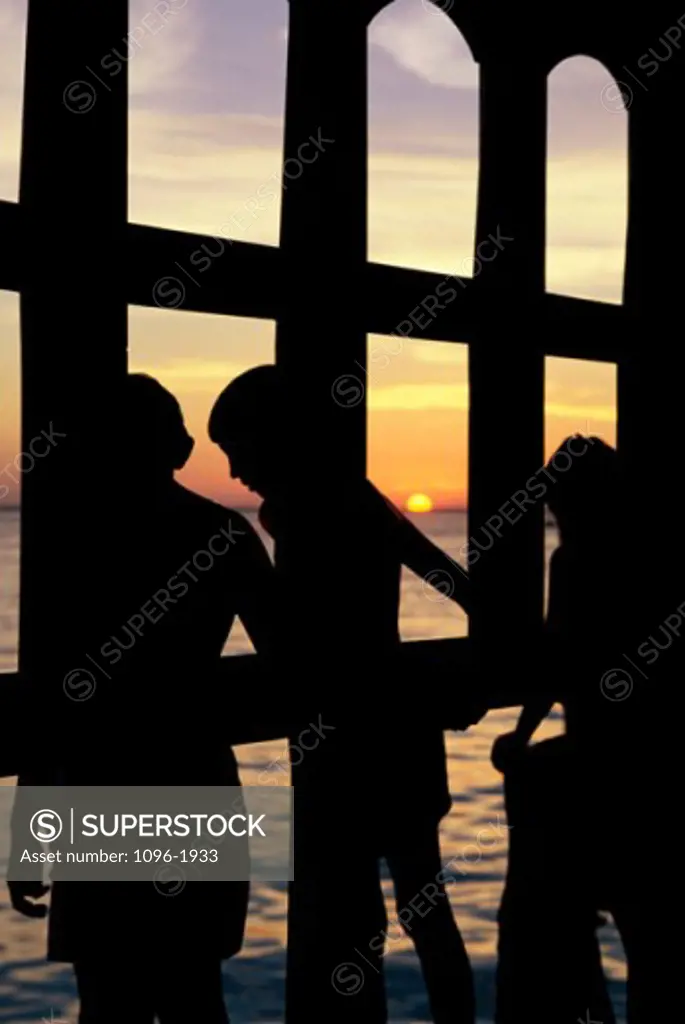 Silhouette of three boys standing together