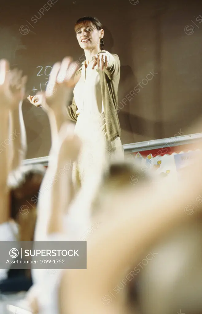 Female teacher pointing towards her students in a classroom