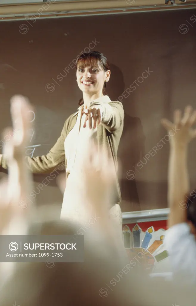 Female teacher pointing towards her students in a classroom