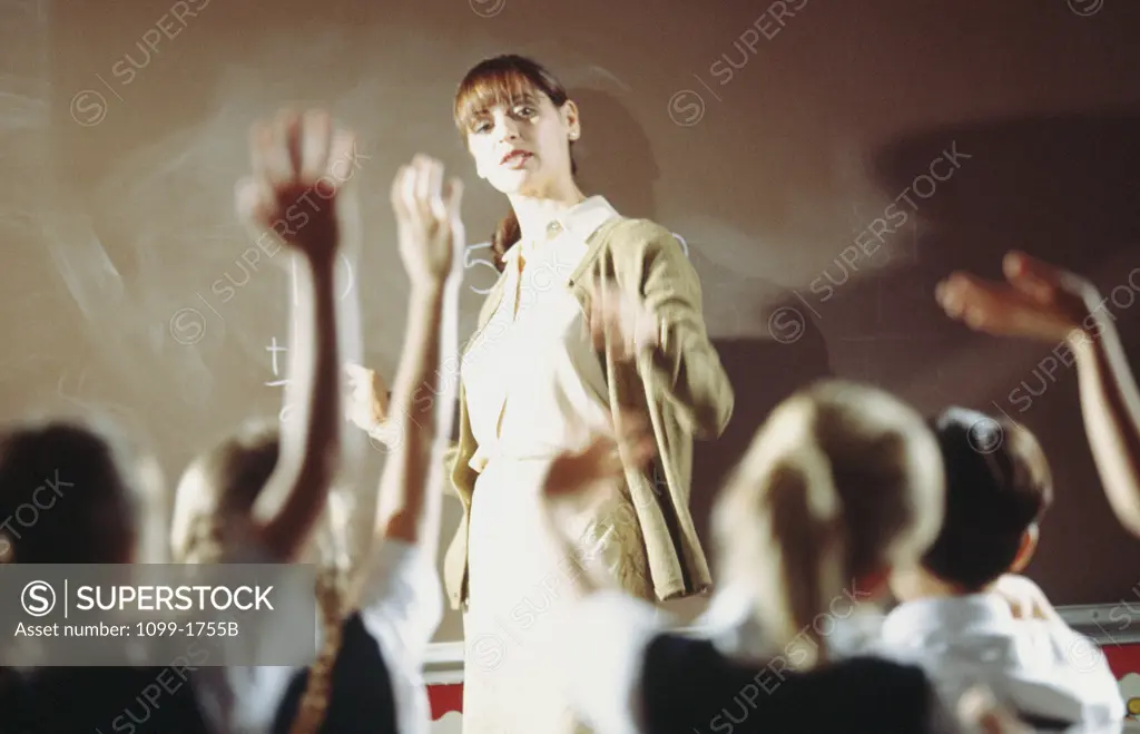 Female teacher pointing towards her students in a classroom