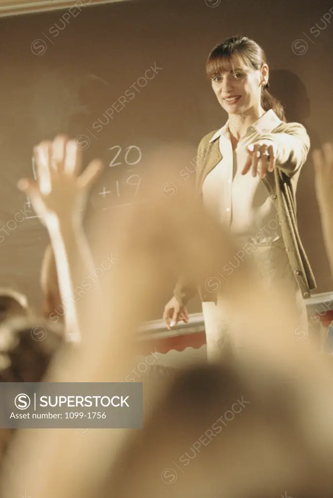 Female teacher pointing towards her students in a classroom