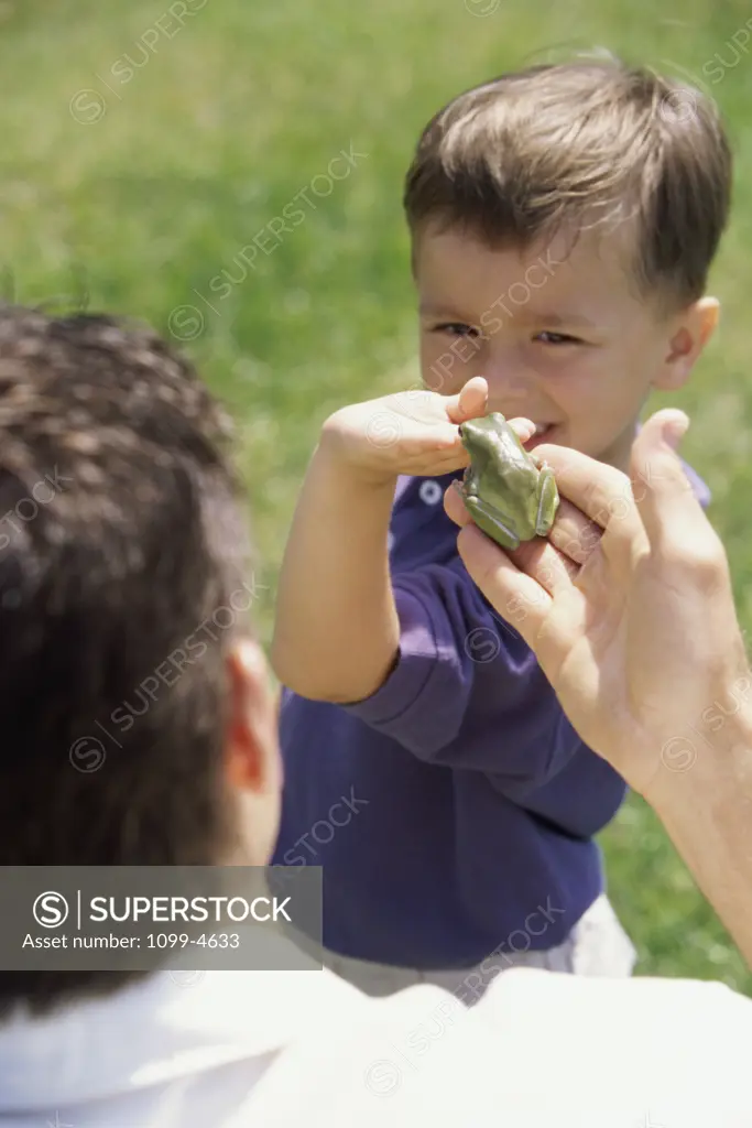 Father giving his son a frog