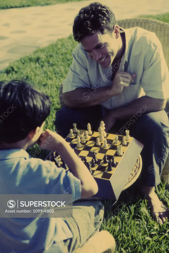 Father playing chess with his son