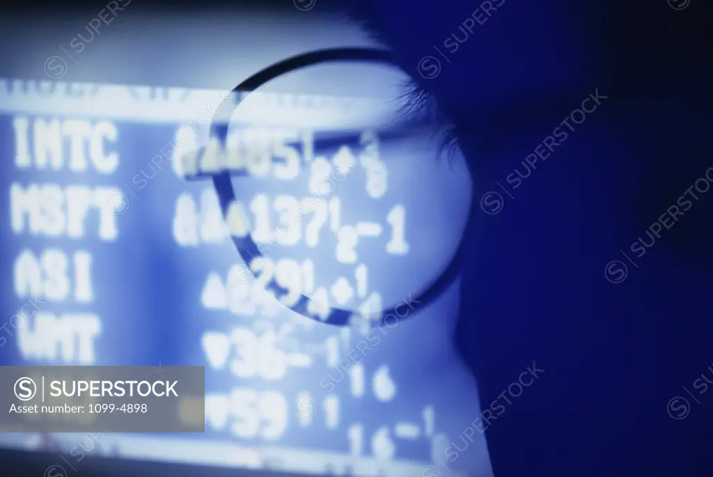 Close-up of a human face with a computer monitor in the background