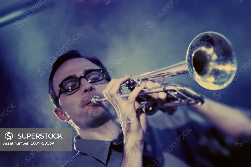 Low angle view of a young man playing the trumpet