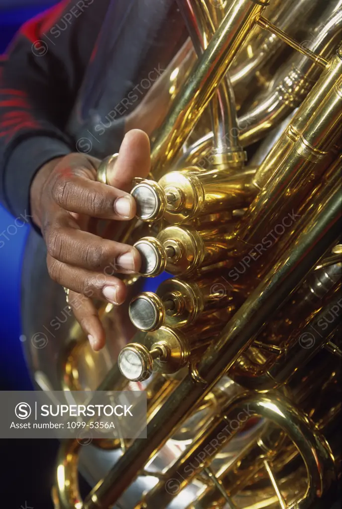 Close-up of a person's hands playing the tuba