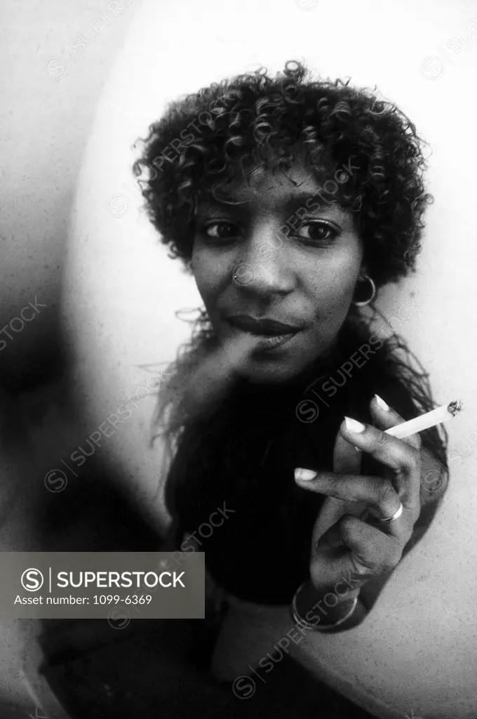 High angle view of a young woman blowing smoke