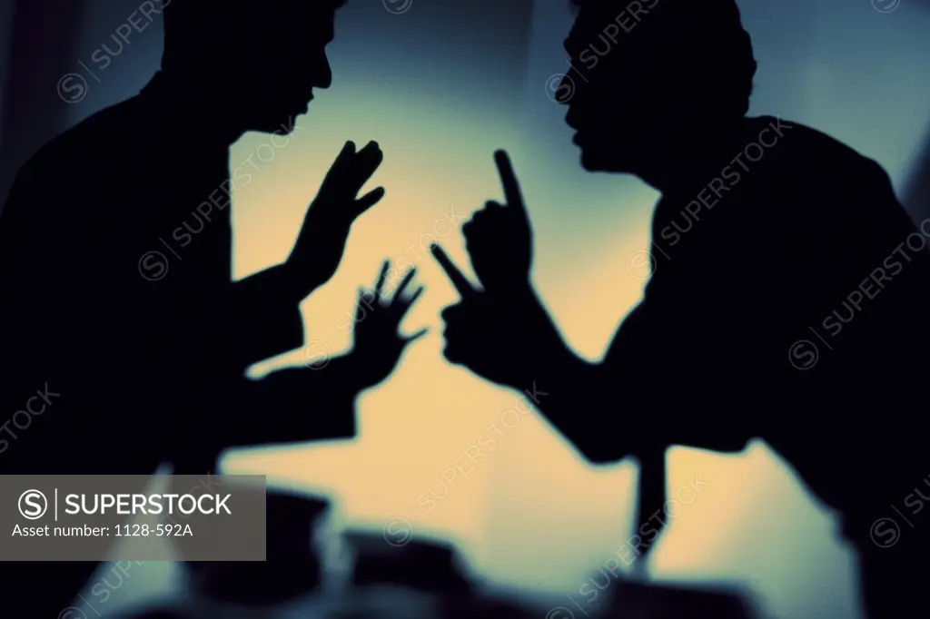 Silhouette of two businessmen arguing in an office