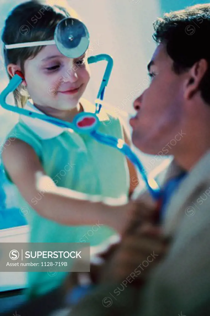 Girl pretending to be doctor, examining her father