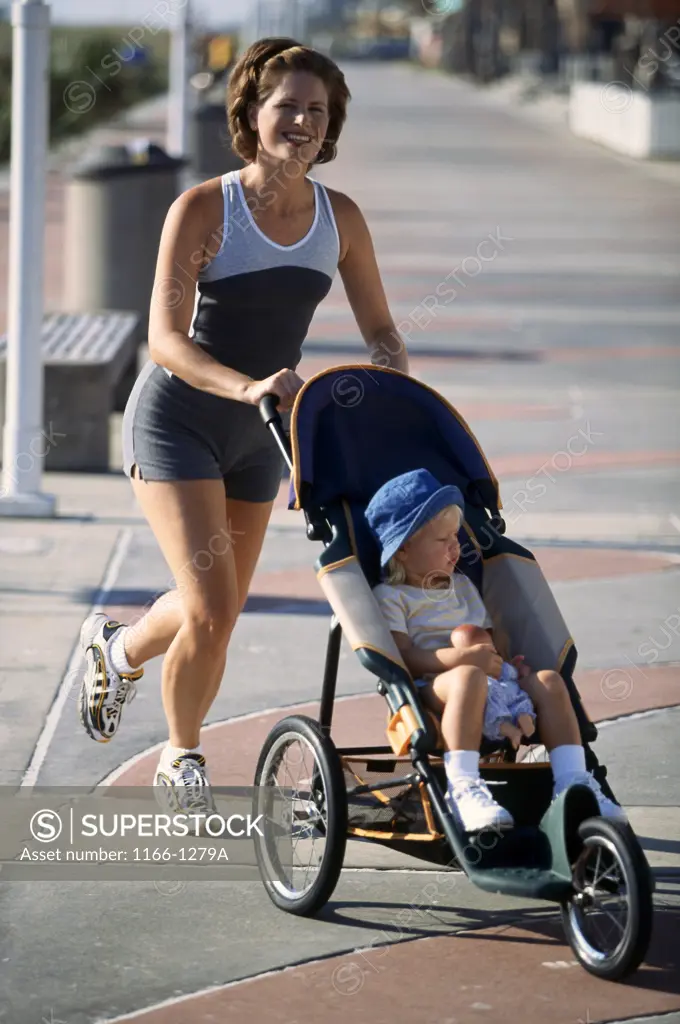 Portrait of a mid adult woman pushing her daughter in a stroller