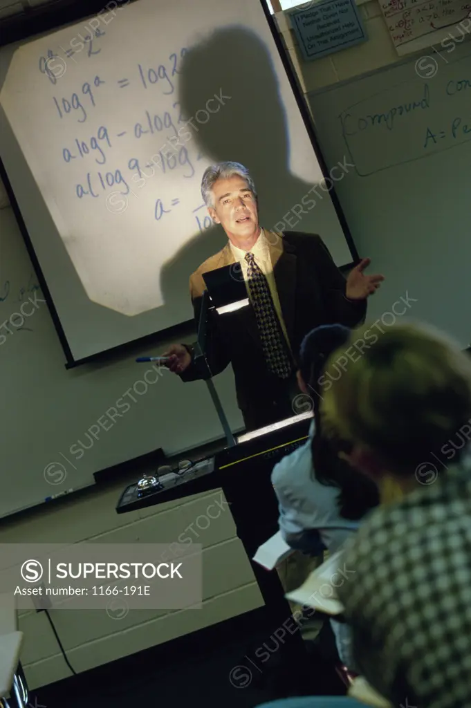 Male teacher explaining with the help of an overhead projector