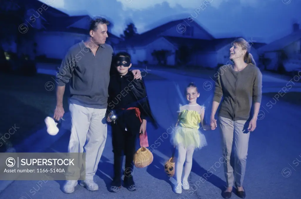 Parents trick or treating with their son and daughter