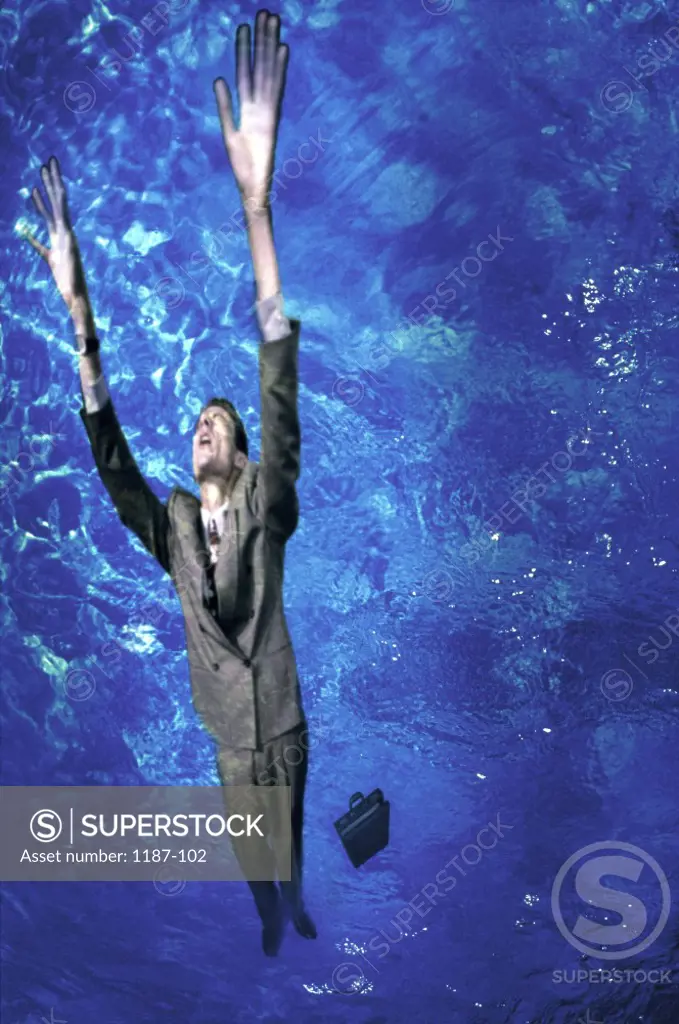 Low angle view of a businessman drowning in a swimming pool